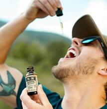 a man administrating cbd oil. 