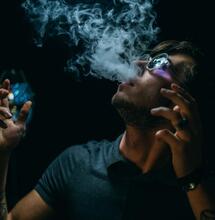 young man releasing a fume out of his mouth. 