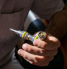 a man holding a pipe filled with cannabis, a known remedy in the treatment of eating disorders