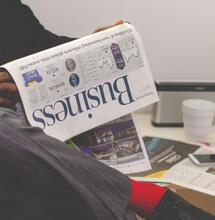 man in suit reading finance news.