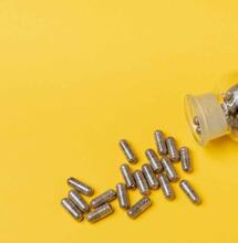 THC CBD capsules against a yellow background.