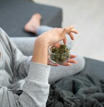 Persona viendo series cannábicas en casa con un porro