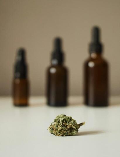 botellas sobre una mesa y un cogollo de marihuana