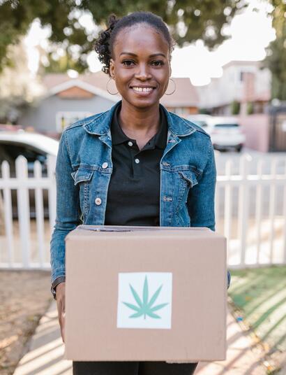 Woman holdiong box with a cannabis leaf on it