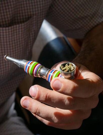 a man holding a pipe filled with cannabis, a known remedy in the treatment of eating disorders