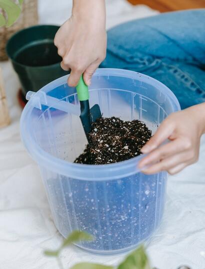 mixing soil and fertiliser in a bucket