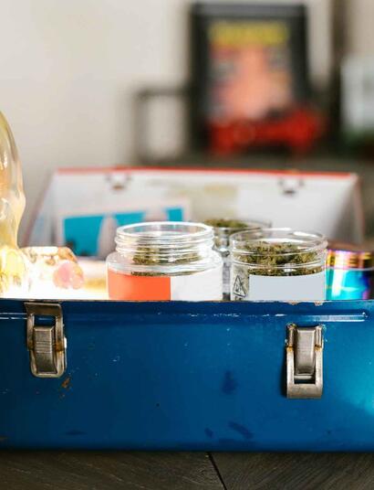 steel case with a glass bong and jars with weed.