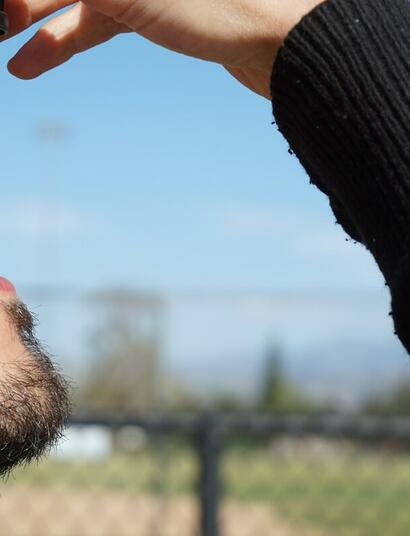 a man is taking a drop of CBD oil, which is available as full-spectrum, broad-spectrum and isolate form 