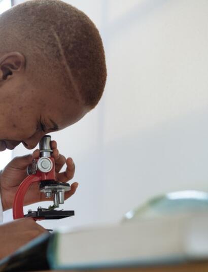 scientist looking through microscope