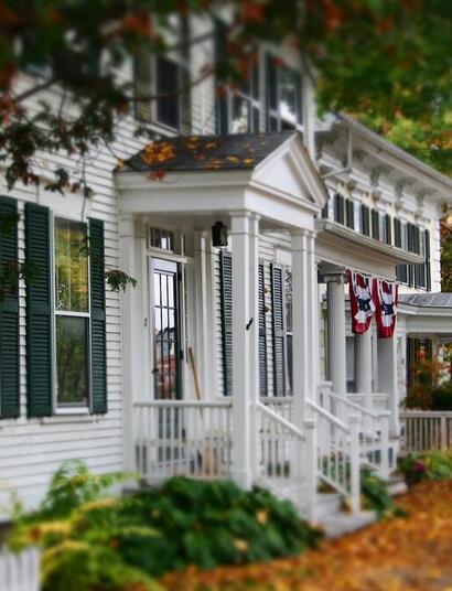 The US flag protruding from a traditional New England house along the Green in Woodstock, Vermont.
