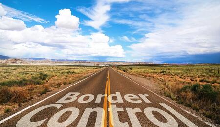 "Border Control" letter sign on a highway passing through a field in what feels like typical New Mexico landscape. 
