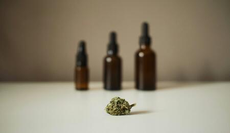 botellas sobre una mesa y un cogollo de marihuana
