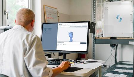 An orthopedic doctor is looking at a patient's hand scans. 