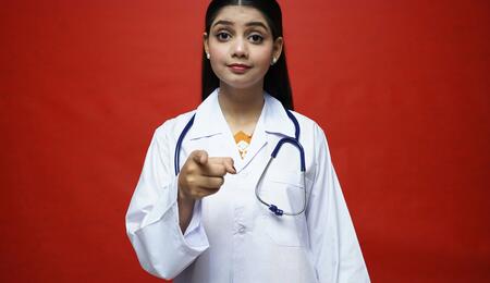 Doctora apuntando con el dedo en señal de prejuicio hacia un paciente, ilustrando el concepto de Stinkma o estigma por olor a cannabis en la consulta médica.