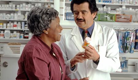 hombre farmaceutico atendiendo a mujer mayor