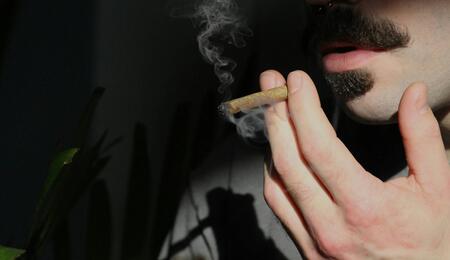 Persona fumando marihuana en un espacio privado