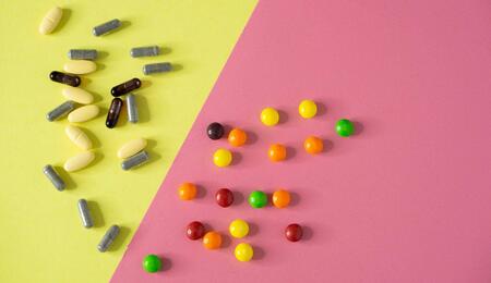 bunch of pills against yellow pink background.