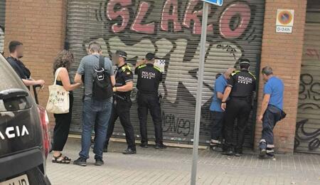 Agentes de policía precintan la puerta de un club de cannabis en Barcelona