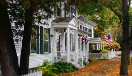 The US flag protruding from a traditional New England house along the Green in Woodstock, Vermont.