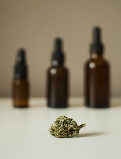 botellas sobre una mesa y un cogollo de marihuana