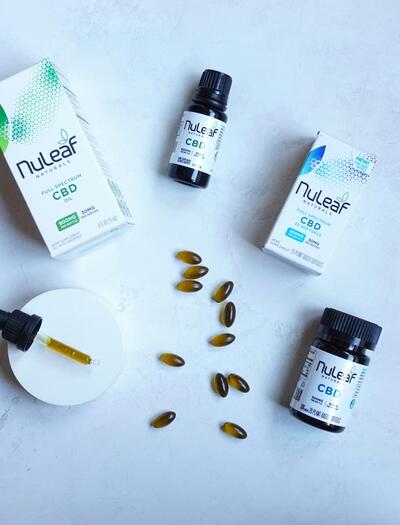 Composición profesional de productos de cannabidiol (CBD) en aceite y cápsulas sobre un fondo limpio. La imagen representa la estandarización y variedad de formatos de administración analizados en el meta-análisis de Lattanzi sobre la epilepsia.