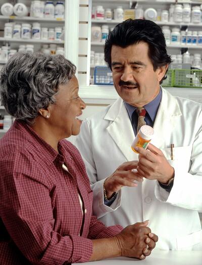 hombre farmaceutico atendiendo a mujer mayor
