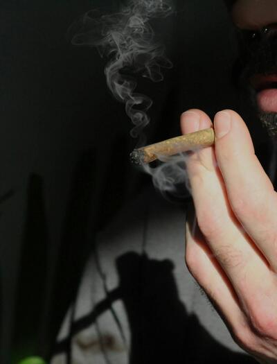 Persona fumando marihuana en un espacio privado