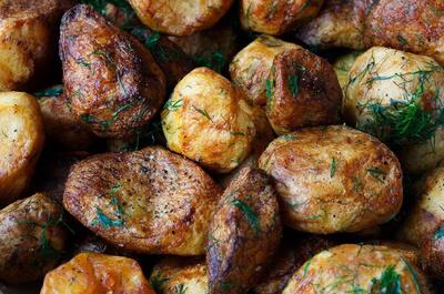 a close-up shot of camp baked potatoes with greens and spices