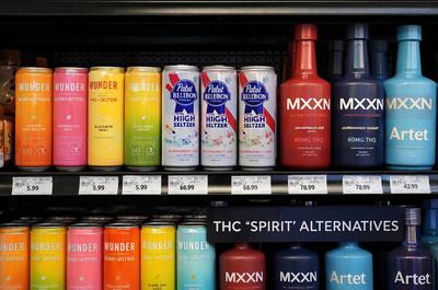 A retail shelf showing a variety of colorful THC seltzers and "Spirit" alternatives like MXXN or Artet.