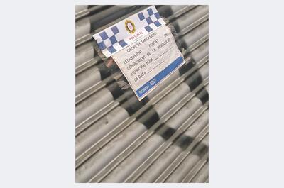 Persiana bajada con precinto policial en un club cannábico cerrado de Barcelona