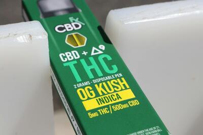 an image of green-colored dispensable cannabis pen with yellow letters on the bottom that reads OG Kush indica with 5 mg THC and 500 mg CBD.