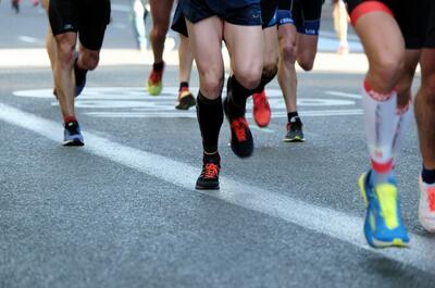 Runners participating in a road race, illustrating the benefits of regular physical activity for overall health and sleep.