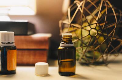 Amber glass bottles of CBD oil displayed on a table in a softly lit interior, representing cannabis wellness products.