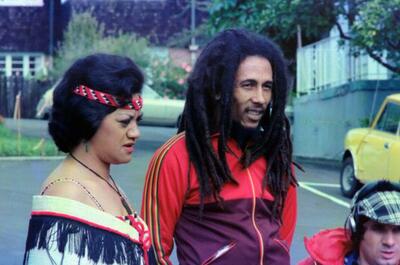 an image of Jamaican reggae legend and cannabis advocate Bob Marley standing next to a woman on a street in Auckland, New Zealand, during his 1979 Babylon on Bus tour.